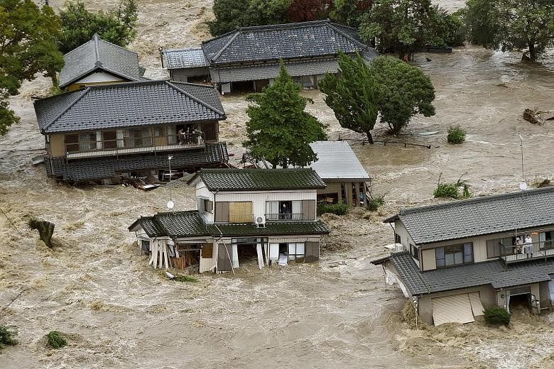 People waiting on the upper floor of their homes for rescue helicopters in a flooded residential area in Joso city, Ibaraki prefecture, in this photo taken by Kyodo yesterday. The city was flooded when the swollen Kinugawa river burst its banks in th
