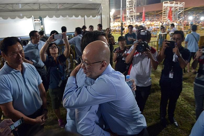 Workers' Party supporters giving Ms Lee Li Lian their support during her concession speech. She lost to the PAP's Charles Chong in Punggol East. WP candidate for Marine Parade Terence Tan (foreground) hugging Mr Ron Tan (candidate for Nee Soon) as th