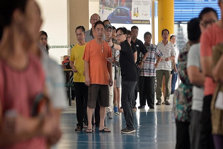 People waiting to cast their ballots at Pei Chun Public School in Toa Payoh Lorong 7 yesterday. At polling stations, many voters formed long lines long before the opening time of 8am. Candidates from various parties were also seen visiting various po