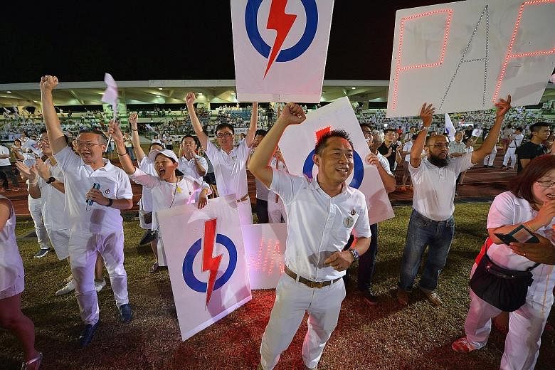 PAP supporters cheering at Bedok Stadium as they awaited the results last night.