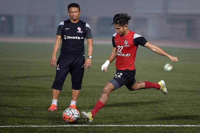 Christopher van Huizen taking a shot at training, watched by LionsXII coach Fandi Ahmad. Used chiefly as a substitute this season, the winger has the ability, says Fandi, to come on late in a game and make an impact.