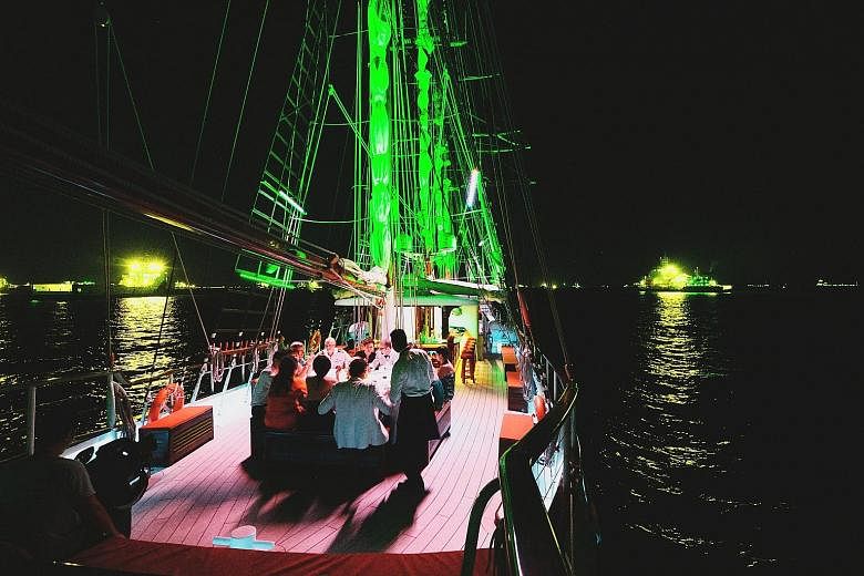 A private dinner party on board a yacht (above). Some charter firms offer standing paddle boards and giant floats (left) for guests to have a soaking good time.