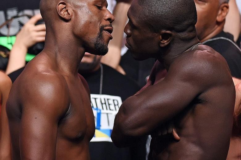 Floyd Mayweather (left), with Andre Berto during their official weigh-in before their bout in Las Vegas, will match Rocky Marciano's 49-0 record if he, as expected, wins. Many fans have criticised his choice of opponent, saying other boxers deserve a