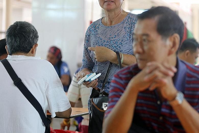Left: A Thai woman selling tissue paper at Haig Road Food Centre. Below: A woman selling tissue paper at Geylang Serai Market and Food Centre recently. Such able-bodied foreigners are upsetting elderly or disabled Singaporeans who are earning a livin