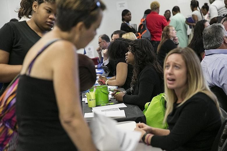 Representatives at a job fair in Dallas, Texas, speaking with job-seekers earlier this month. The US Labour Department said last Friday that unemployment fell to 5.1 per cent last month, the lowest rate in over seven years.