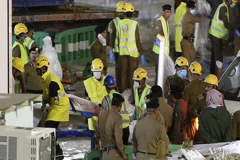 Emergency workers in Saudi Arabia removing a body from the site of the crane accident. The governor of the Mecca region, Prince Khaled Al-Faisal, has ordered an investigation into the incident. REUTERS The construction crane collapsed onto Mecca's Gr