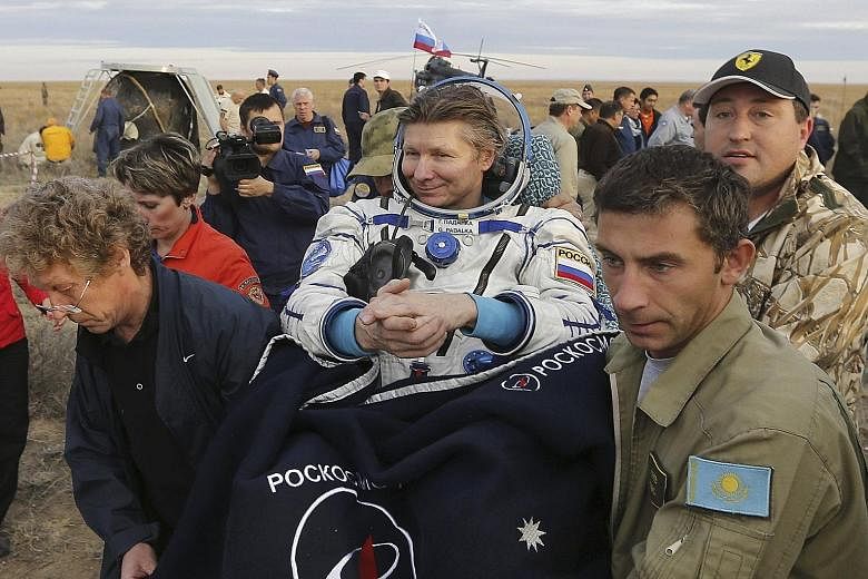Ground staff carrying Mr Gennady Padalka after he landed near the town of Zhezkazgan, Kazakhstan, yesterday. The Russian cosmonaut, who led the 44th expedition at the International Space Station, has spent a record 879 days in space over five separat