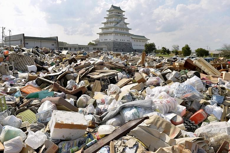 Household items damaged by flooding piling up at a waste-collection point in Joso. More than 4,000 houses there were submerged and over 1,650 people were still at evacuation facilities yesterday afternoon.
