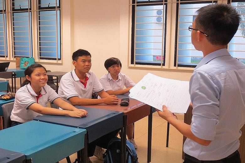 Dunman High students (from left) Law Xiao Xuan, Daniel Lee and Quek Zi Ning, all 17, are among the first in Singapore to take translation as an A-level subject. Their teacher Liu Zhiqiang snaps photos of any translation errors he spots in public area