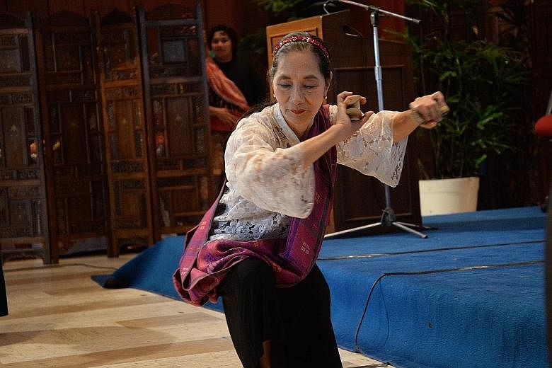 Left: Ms Ligaya Amilbangsa, 72, performing the pangalay, an ancient dance she has devoted her life to saving. She describes it as a cry for stillness in a world of violent shoving. Below: A dancer showing the audience the finer points of the slow dan