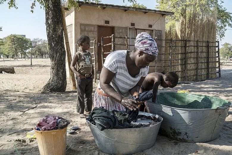 Ms Othusitse Ndozi doing laundry outside her home in Sanyuko, a remote village close to the Moremi Game Reserve in Botswana. Her husband once earned about US$100 (S$141) a month as a tracker and driver before trophy hunting was banned.