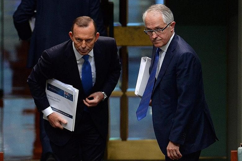 Mr Tony Abbott (left) and Mr Malcolm Turnbull at Parliament House in Canberra yesterday. Mr Turnbull has indicated that his top priority will be to focus on the economy and innovation.