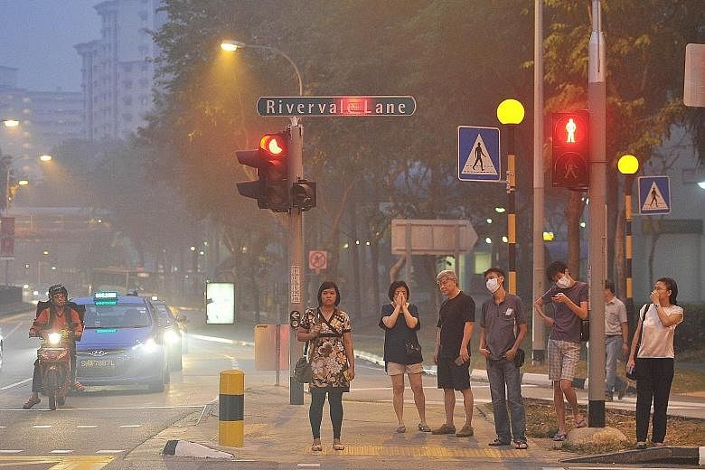 Hazy conditions causing discomfort to pedestrians near Rivervale Plaza at about 7pm yesterday. At 9pm yesterday, the 24-hour PSI was between 133 and 166.