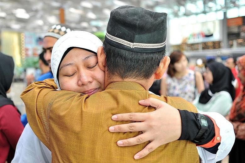Nurse Nur Asyiqin Jumari (left), 30, hugging her father, retired bus driver Jumari Suri, 65, at Changi Airport yesterday. She was among the latest batch of Muslim Singaporeans pilgrims heading to Mecca for their haj. Dr Yaacob Ibrahim was there to se