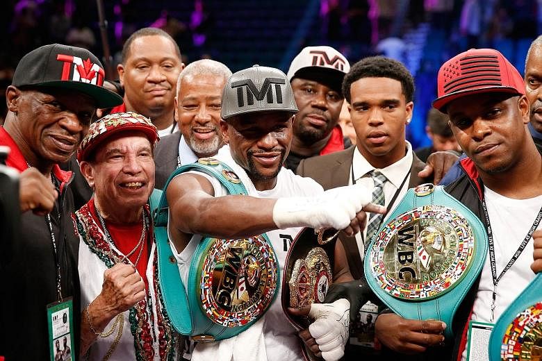 Floyd Mayweather (centre) keeps his unbeaten record intact after beating Andre Berto but many pundits do not see him in the class of true greats like Muhammad Ali, Roberto Duran and Sugar Ray Robinson.
