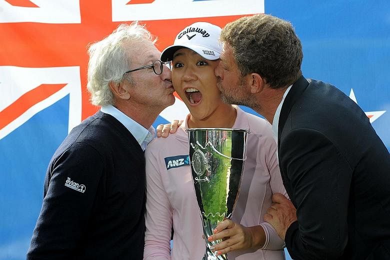 New Zealand's Lydia Ko is kissed by French dairy food giant Danone chairman Franck Riboud (far left) and director of the Evian tournament, Jacques Bungert, as she celebrates with her trophy after winning the Evian Championship.