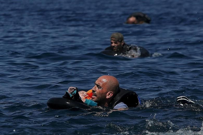 Migrants swimming to shore in lifetubes after their dinghy deflated some 100m from the Greek island of Lesbos on Sunday. European interior ministers yesterday held crisis talks, with Germany, France and the bloc's executive commission trying to overc