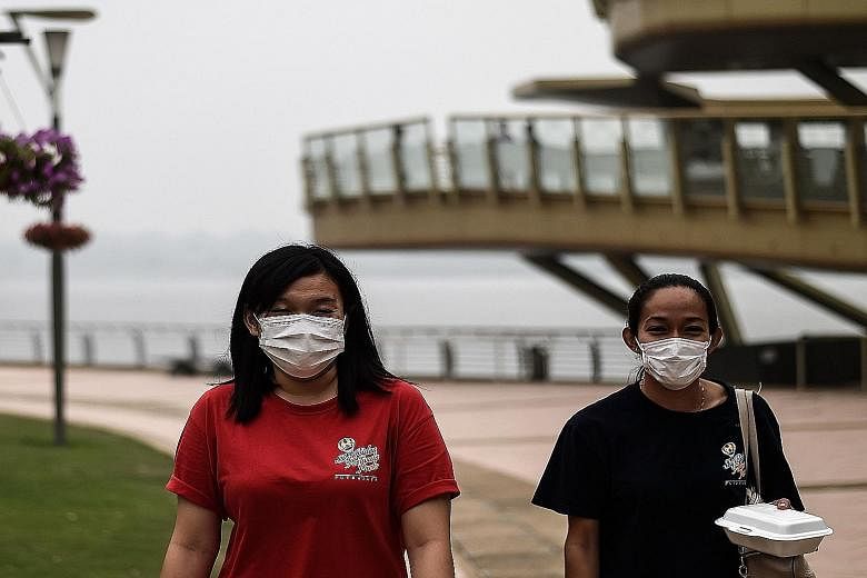 Women wearing masks because of the haze in Putrajaya, Malaysia, on Sunday. The haze problem persists because its systemic causes are not being addressed.