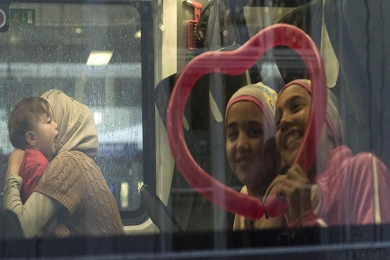 Migrants on board a train to Germany at the train station in Salzburg, Austria, on Monday. Germany reintroduced early this week controls on its frontiers with Austria, through which most migrants arrive.