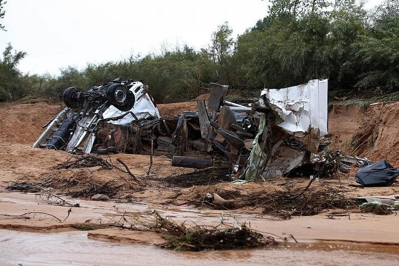 The twisted wreckage of two vans that were washed away in a flash flood with women and children inside in Hildale, Utah. Flash floods in Utah have left at least 12 people dead.