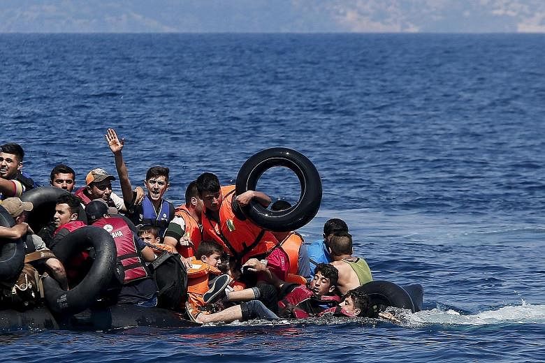 Above: Refugees falling into the sea after their dinghy deflated before reaching the Greek island of Lesbos on Sunday. Left: Refugees entering a registration camp after they crossed the border between Greece and Macedonia yesterday.