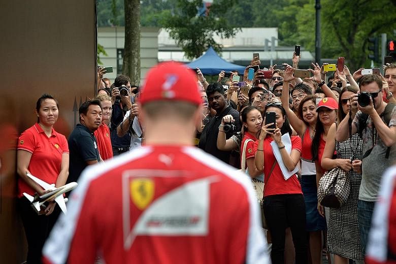 All eyes are on Ferrari's Kimi Raikkonen when he arrives at a UPS event in front of Raffles City (left). The Finn is at ease in an interview at the Shell Trackside Laboratory (above), noting that his team have gone into overdrive to make changes for 