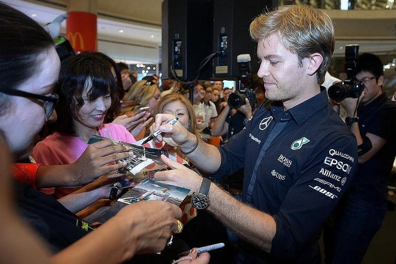 Nico Rosberg signing autographs for fans at Suntec City. The German knows he needs to take more risks to close the 53-point gap.