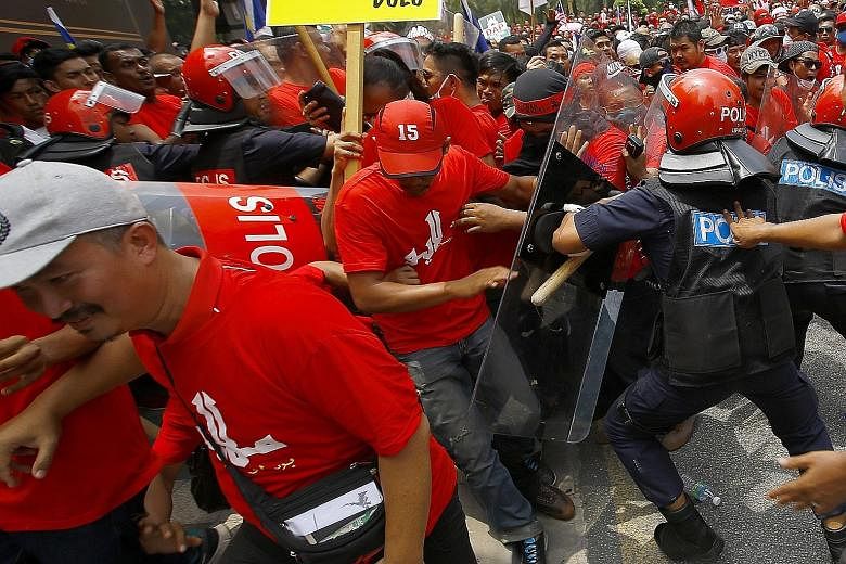 Groups of red shirt protesters scuffled with riot police during the rally in Kuala Lumpur, Malaysia, on Wednesday.