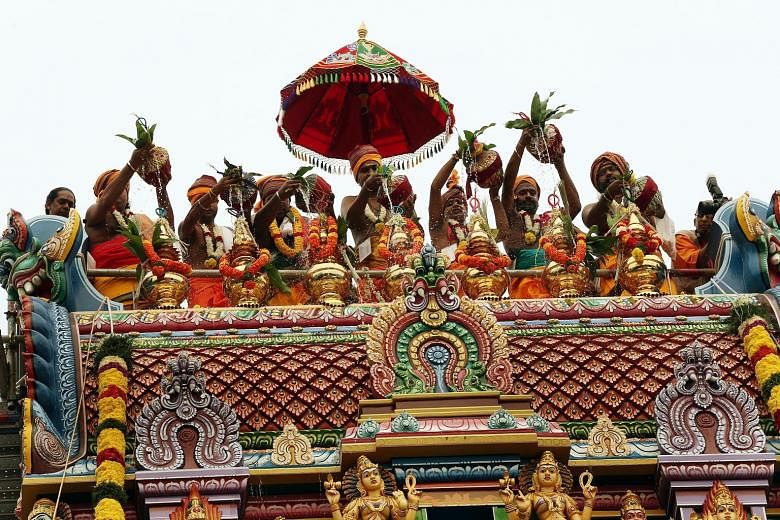 South Indian priests scaled the gopuram or tower of the Sri Ruthra Kaliamman Temple in Depot Road yesterday to sprinkle holy water from nine sacred Indian rivers, such as the Ganges, on its rooftop kalasams - vessel-like pinnacles that point to the s