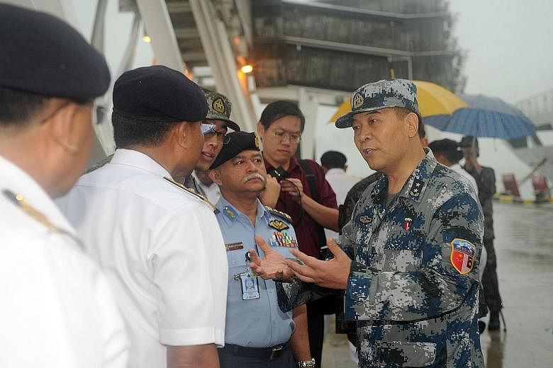 Deputy Chief of General Staff of the Chinese PLA Yi Xiaoguang (above, right) talking to Malaysian military officers as Chinese navy vessels (left) arrived for the joint military exercise in Port Klang, Malaysia, on Thursday.