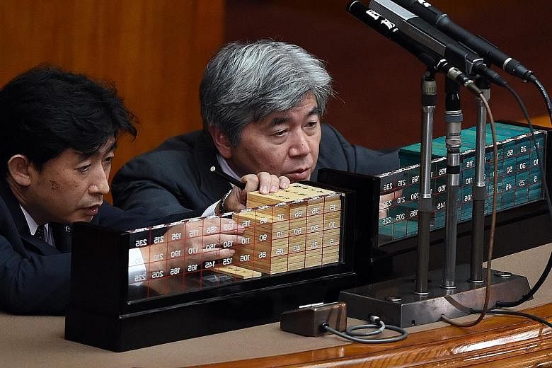 Ballots being counted in Parliament in Tokyo yesterday. The security Bills were expected to pass as Japanese Prime Minister Shinzo Abe's ruling coalition holds a majority in both houses of Parliament.