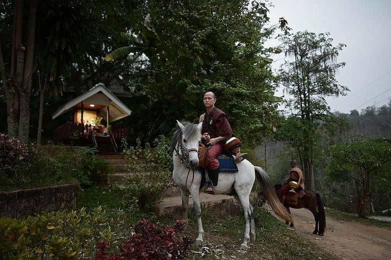 Buddhist novice Ponsakorn Mayer leaving the Temple of the Golden Horse on horseback with other monks to collect alms. His father was a drug addict and did not work.