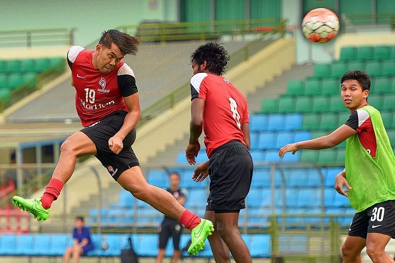 Khairul Amri (No. 19) winning a header against LionsXII team-mate Madhu Mohana during training at Jalan Besar Stadium yesterday. The forward has plundered nine goals in the Malaysian Super League and the Malaysian FA Cup.