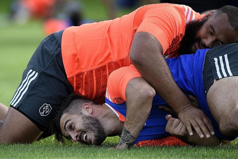 France's Sofiane Guitoune (below) feeling the full weight of his team-mate, prop Uini Atonio, during a training session at the Trinity School in Croydon this week. Atonio, who weighs 141kg, is the heaviest player in the Rugby World Cup.