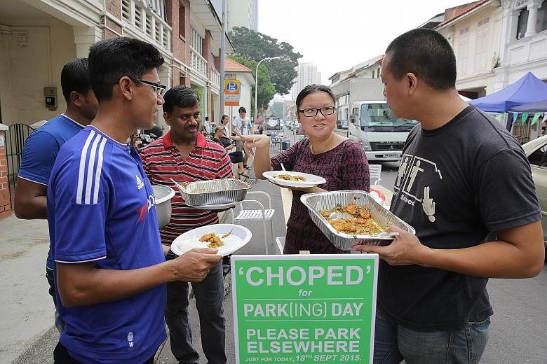 Construction firm boss Shannon Lim and his employees (from left) Farhad Hossain (partially blocked), Monir Hossain and Kasinathan Thirunavukarasu interacting with participant Toh Yi Rong at a Park(ing) Day event yesterday in Little India. They served