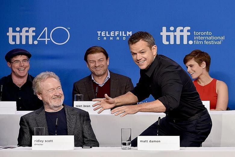 Ridley Scott (second from left) directs The Martian written by Andy Weir (left, behind Scott), which stars Matt Damon (second from right), Sean Bean (centre) and Kate Mara (right).
