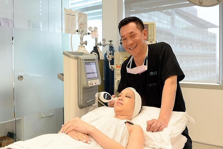 Dr Ivor Lim, with a member of his staff and a genuine Thermage machine, showing how treatment is carried out. A genuine machine costs more than $80,000 while a fake one goes for between $18,000 and $38,000.