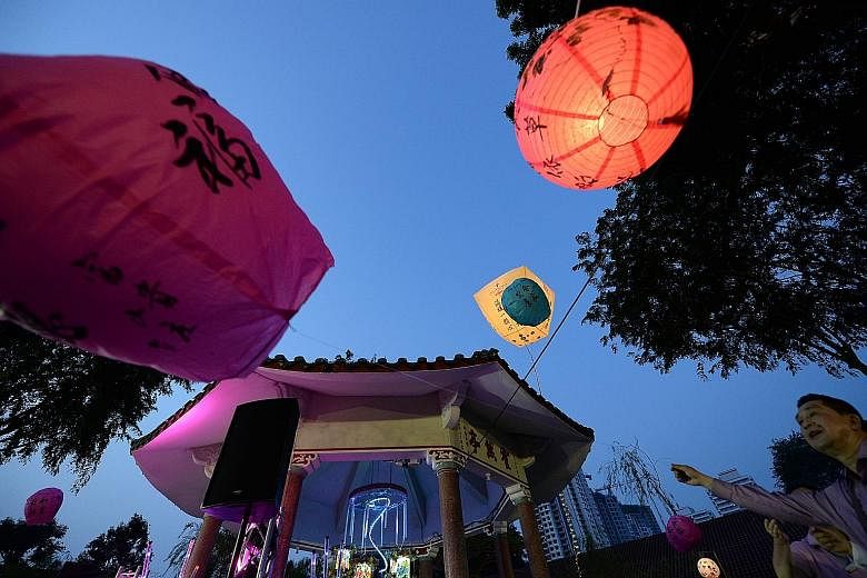 A giant lantern (above) being released into the sky at Kwong Wai Siu Hospital's mid-autumn celebration on its grounds last Saturday. Shaanxi Association president Zhao Bingli (left) and his wife, Shuran, singing at the clan's first Mid-Autumn Festiva