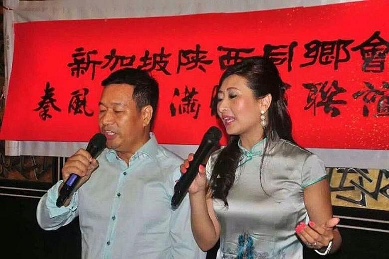 A giant lantern (above) being released into the sky at Kwong Wai Siu Hospital's mid-autumn celebration on its grounds last Saturday. Shaanxi Association president Zhao Bingli (left) and his wife, Shuran, singing at the clan's first Mid-Autumn Festiva