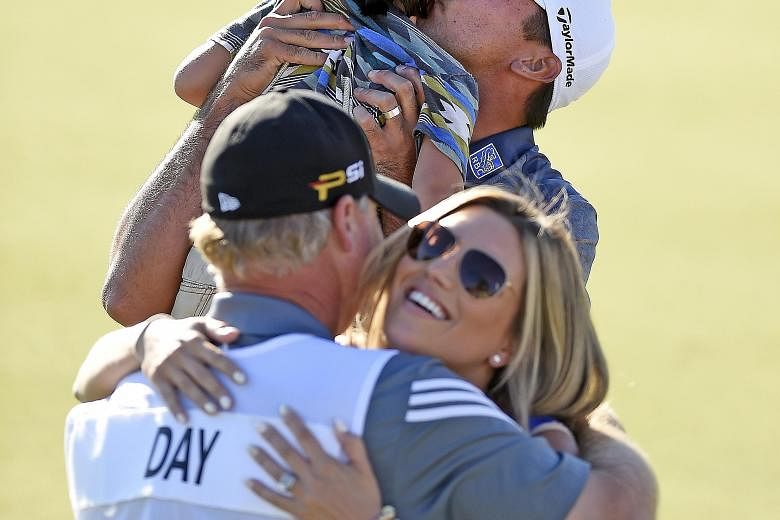 Jason Day holds his son Dash while wife Ellie hugs caddie Colin Swatten after the red-hot golfer bags his fourth title in his last six events, at the BMW Championship.