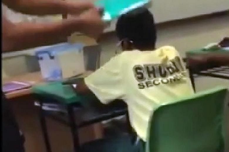 In the clip, two boys are seen keeping their heads bowed and not retaliating as another boy hits them on their heads repeatedly. Meanwhile, yet another boy is seen dancing on the teacher's table.