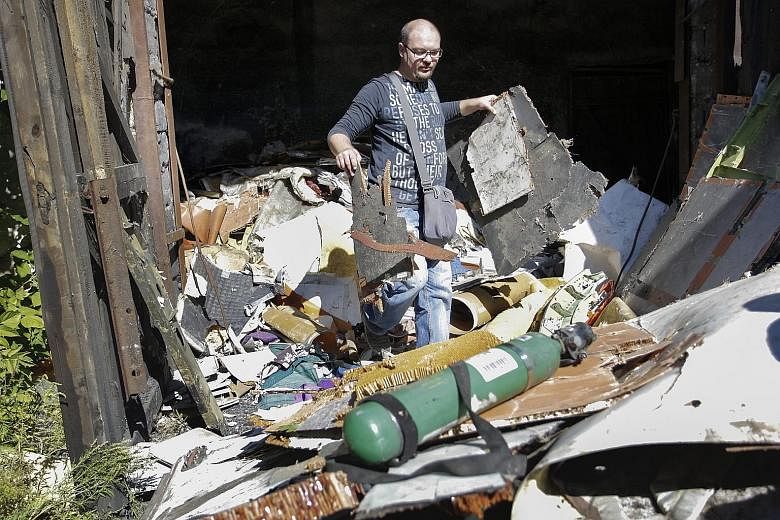 An investigator inspecting the wreckage of Flight MH17 at a village in the Donetsk area of Ukraine on Sept 16.