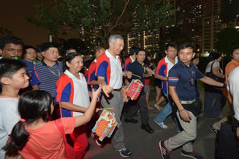 Prime Minister Lee Hsien Loong joining residents in a lantern procession at Bishan-Ang Mo Kio Park last night. Mr Lee said he hoped "we will have a good year ahead and next year will be better".