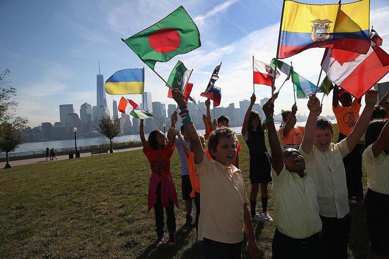 Fourth and fifth graders cheering as immigrants take part in a US naturalisation ceremony on Sept 17 in Jersey City. Immigrant families in the United States trail those in Britain, Canada, France, Germany and the Netherlands when one compares income 