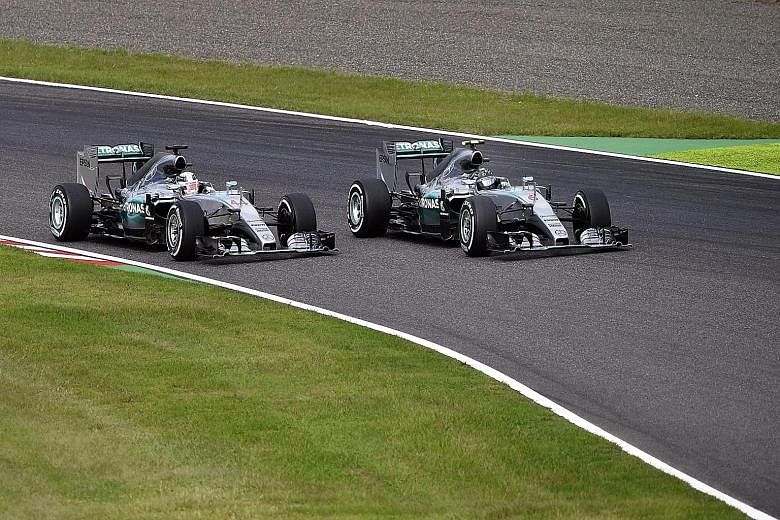 Hamilton (left) overtaking pole-sitter Rosberg at the start of the Japanese Grand Prix to seize the initiative yesterday. He then comfortably held on to the lead to bag his eighth win of the season.