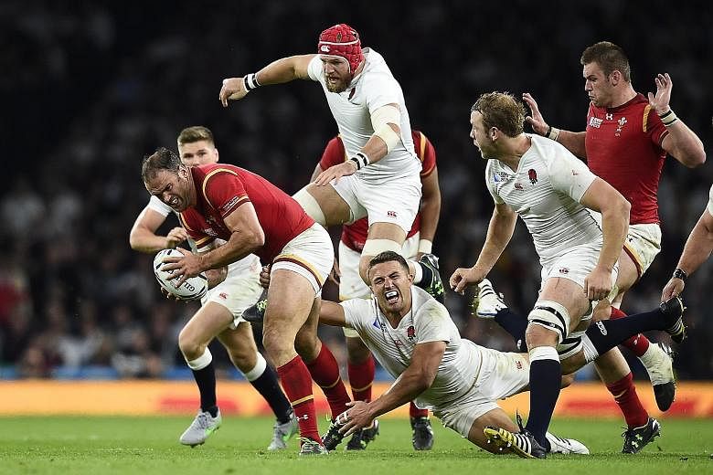 Wales, with Jamie Roberts (with ball) held back by Sam Burgess, beat England 28-25. The hosts now need a victory against Australia.