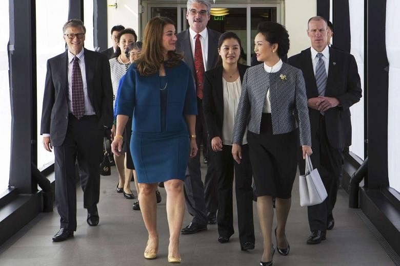 Ms Peng (right) in a power suit at the Fred Hutchinson Cancer Research Center in Seattle, Washington, with Mrs Melinda Gates, wife of Microsoft co-founder Bill Gates. The pairing of a collarless jacket with her white shirt highlights the mandarin collar d