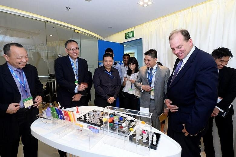 Looking at some items reproduced by 3D printers are EDB executive director of precision engineering Chang Chin Nam (far left); EDB assistant managing director Lim Kok Kiang (second from left); EDB head of precision engineering Kelvin Zin (third from 