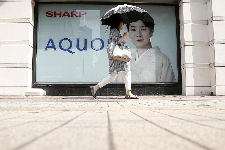 An advertising poster for Sharp's Aquos TV sets outside an electronics shop in Tokyo. Competition from cheaper Asian rivals has shrunk Sharp's market share for television sets.