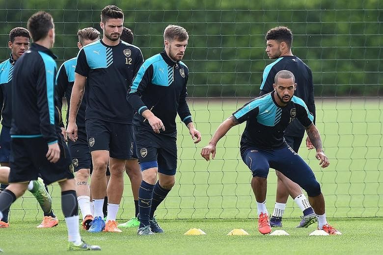Theo Walcott (far right) is confident he can deliver the goods if he is deployed as the sole striker against Olympiakos.